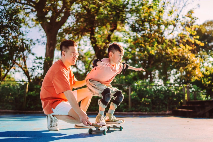 Dad_teaching_son_skateboarding_at_park.webp