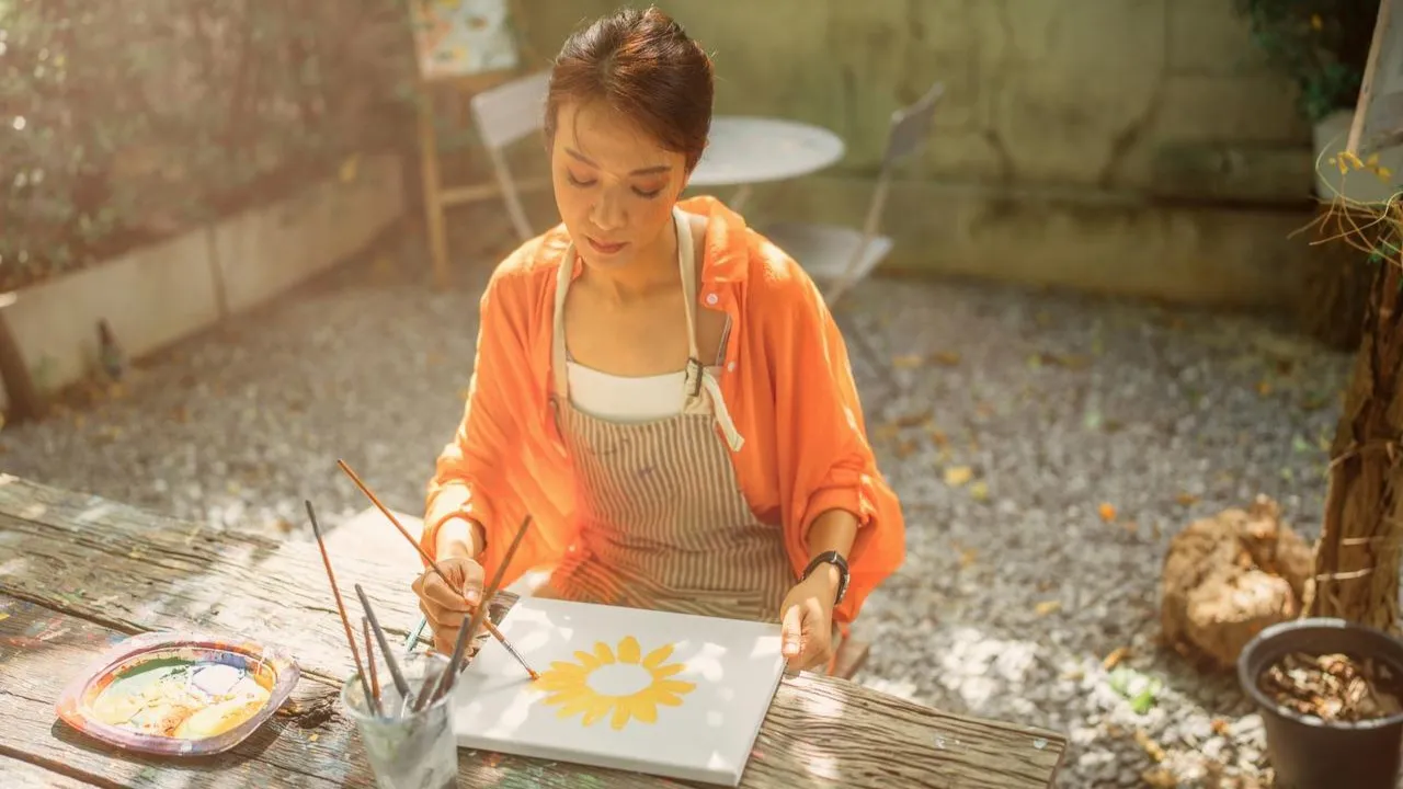 FWD custom stock - Wide shot of a young woman artist painting a landscape on an easel in the forest.webp